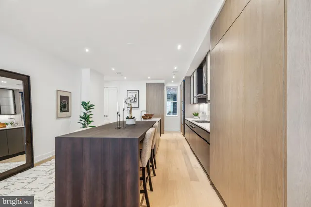 a view of a kitchen with kitchen island a counter top space a sink and cabinets