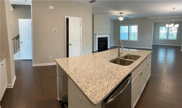 a kitchen with kitchen island granite countertop a sink and a refrigerator
