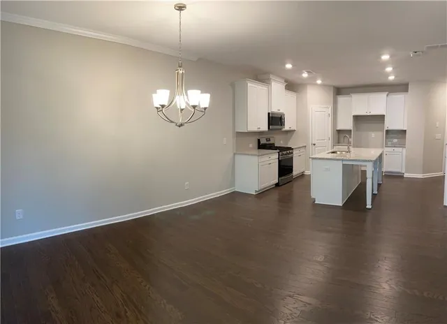 a open kitchen with cabinets wooden floor and stainless steel appliances