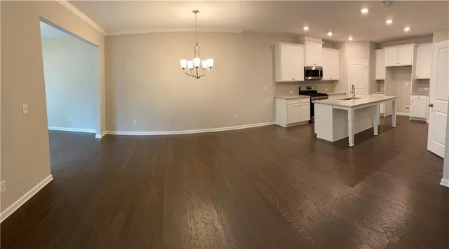 a view of kitchen living space with stainless steel appliances wooden floor and living room view
