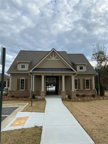 a front view of a house with barbeque oven and outdoor seating
