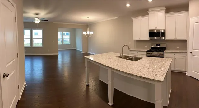 a kitchen with kitchen island a sink appliances and cabinets
