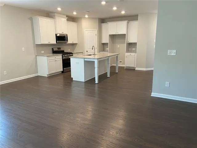 a kitchen with stainless steel appliances kitchen island sink refrigerator and microwave