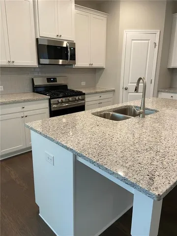 a kitchen with stainless steel appliances granite countertop a sink stove and microwave