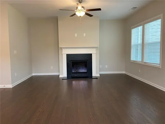 an empty room with windows and a fireplace
