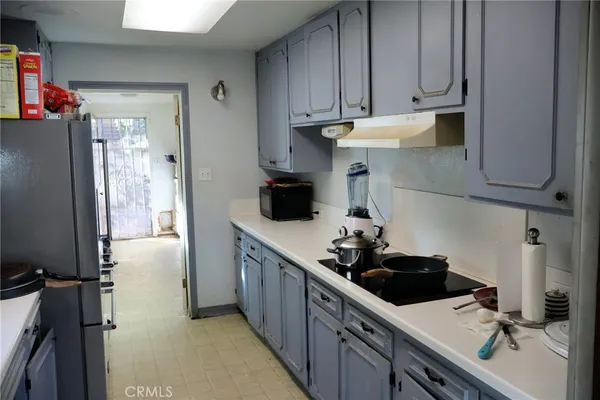 a kitchen with stainless steel appliances a sink a window and cabinets