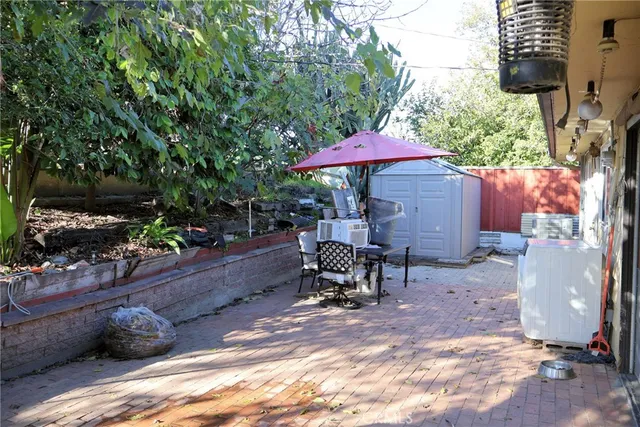 a view of a patio with table and chairs under an umbrella