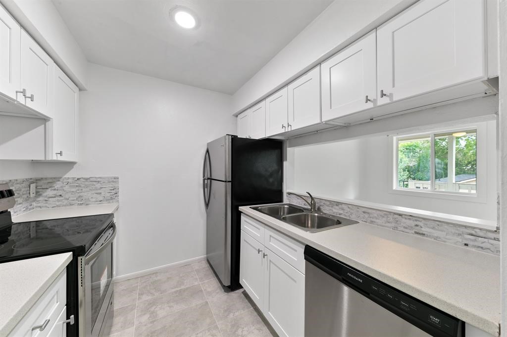 1312 West Adoue Street, Unit 7 Alvin, TX 77511 - Photo 1 of 7 a kitchen with stainless steel appliances granite countertop a sink stove and refrigerator