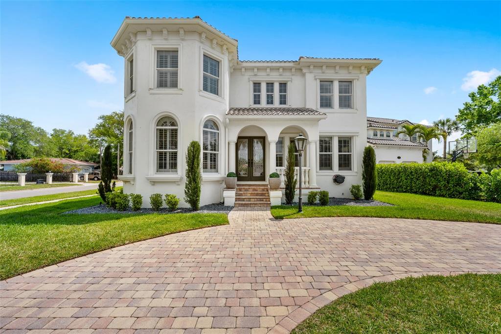 a front view of a house with a yard and trees