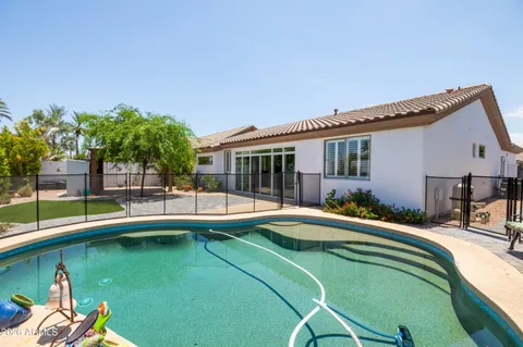 a house view with swimming pool and glass windows