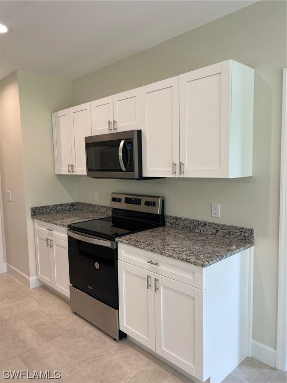 2615 27th Street West Lehigh Acres, FL 33971 - Photo 5 of 17 a kitchen with stainless steel appliances granite countertop white cabinets granite counter tops and a stove