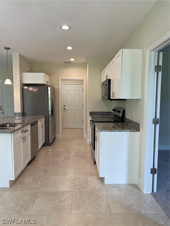 2615 27th Street West Lehigh Acres, FL 33971 - Photo 6 of 17 a kitchen with a refrigerator and a stove top oven