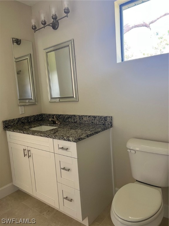 2615 27th Street West Lehigh Acres, FL 33971 - Photo 8 of 17 a bathroom with a granite countertop toilet sink and mirror
