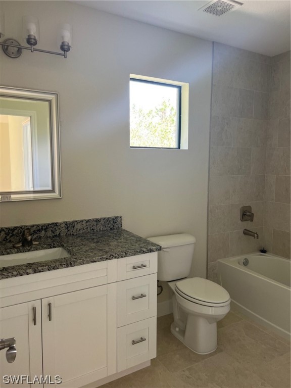 2615 27th Street West Lehigh Acres, FL 33971 - Photo 10 of 17 a bathroom with a granite countertop toilet a sink a mirror and a bathtub