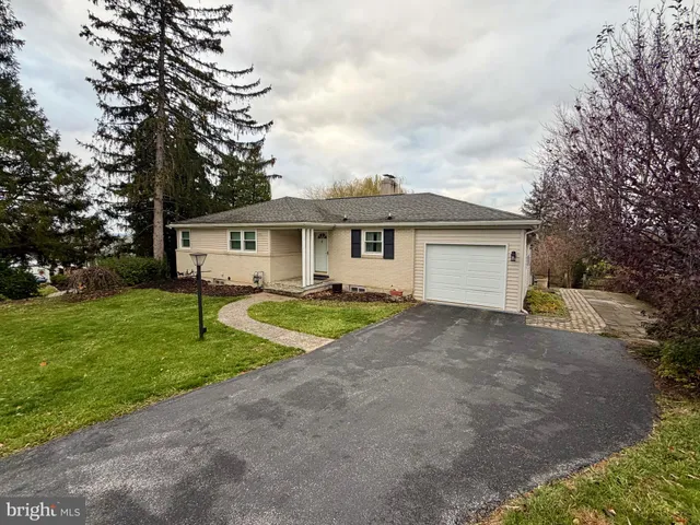 a view of a house with a big yard and large trees