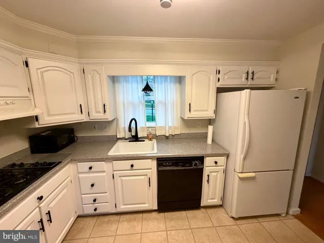 a kitchen with a refrigerator sink stove and cabinets