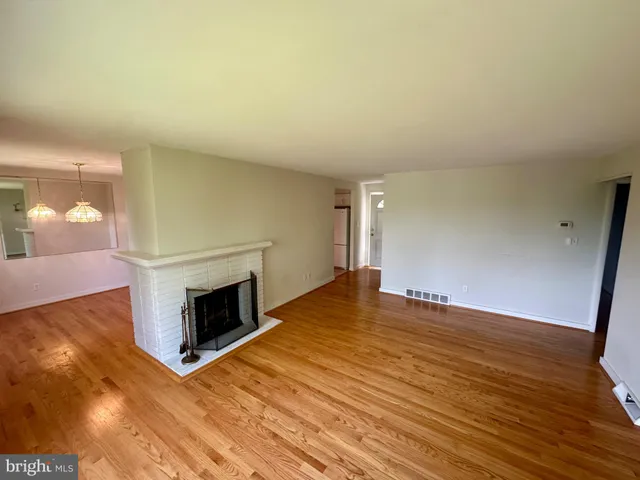 a view of empty room with wooden floor and fireplace