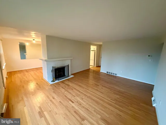 a view of empty room with wooden floor and fireplace