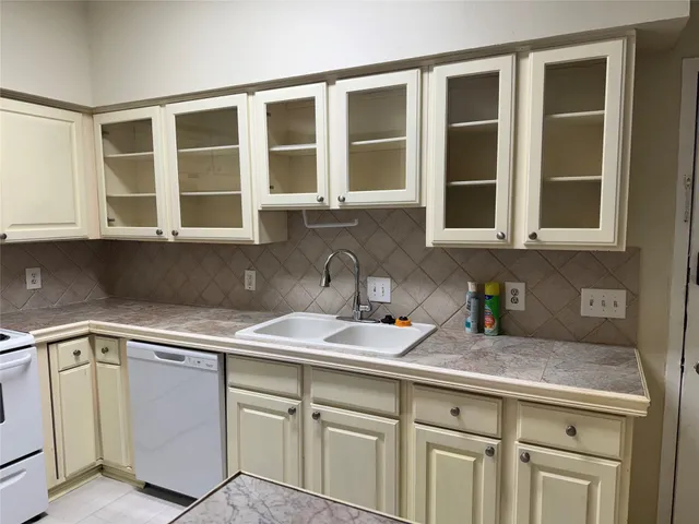 a kitchen with stainless steel appliances granite countertop white cabinets and a sink