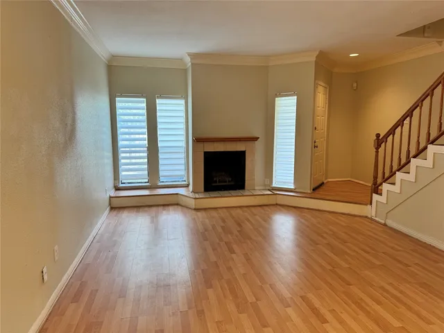 wooden floor fireplace and windows in an empty room