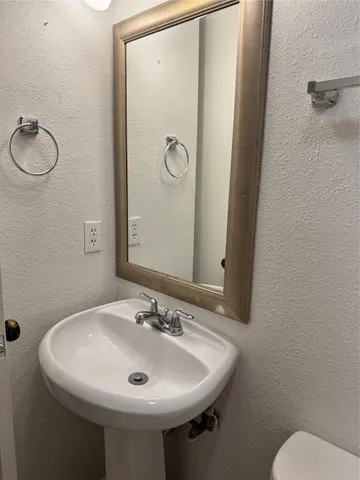 a bathroom with a sink mirror and toilet