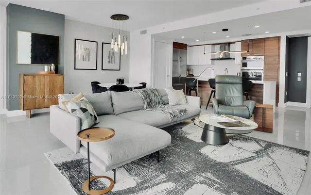 a large kitchen with stainless steel appliances a large counter top a stove and a refrigerator