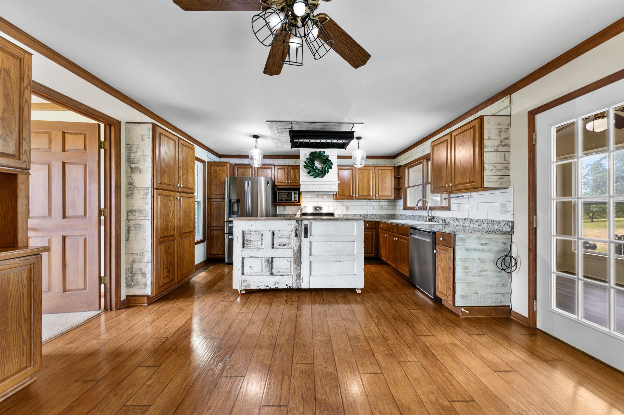 1056 South Cross Bridges Road Mount Pleasant, TN 38474 - Photo 13 of 30 a kitchen with stainless steel appliances granite countertop a stove top oven a refrigerator a sink and dishwasher with wooden floor