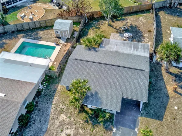 an aerial view of a house with a yard potted plants and large tree