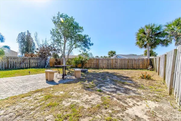 a view of a backyard with table and chairs and wooden fence