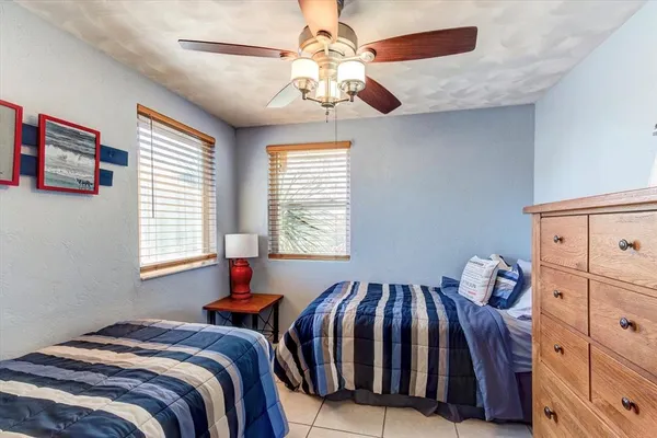 a bedroom with two beds and a chandelier