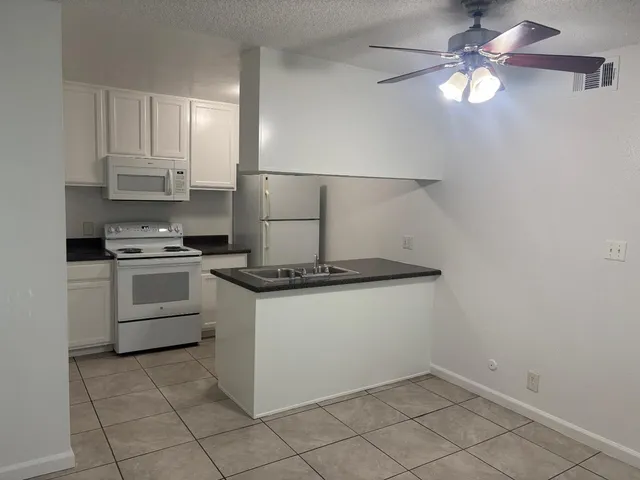 a kitchen with granite countertop a sink and a stove