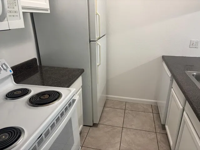 a kitchen with white cabinets and white appliances