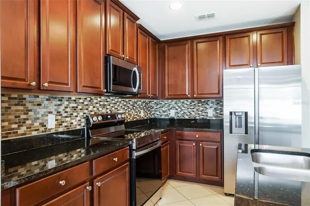 a kitchen with granite countertop stainless steel appliances and wooden cabinets