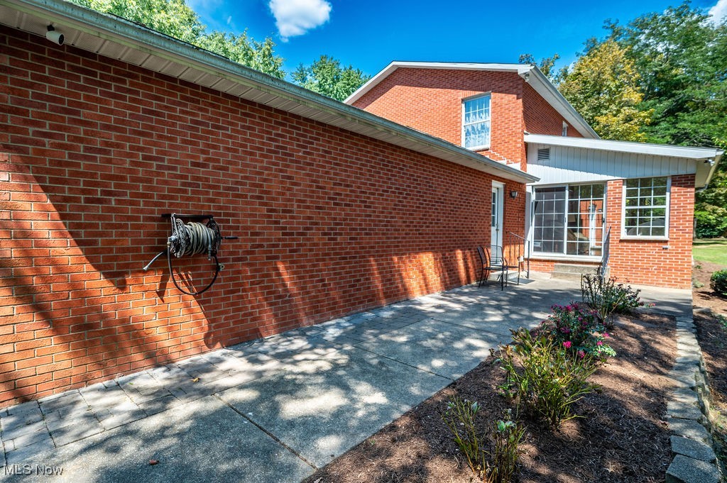 1252 New England Ridge Road Washington, WV 26181 - Photo 42 of 50 View of property exterior with brick siding and a patio area