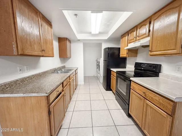 a kitchen with stainless steel appliances granite countertop a stove a sink and a refrigerator