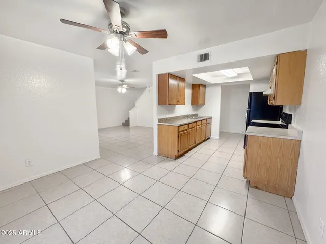 a view of an empty room and chandelier fan