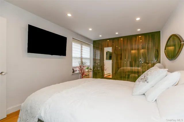a large bedroom with a large bed and a flat screen tv