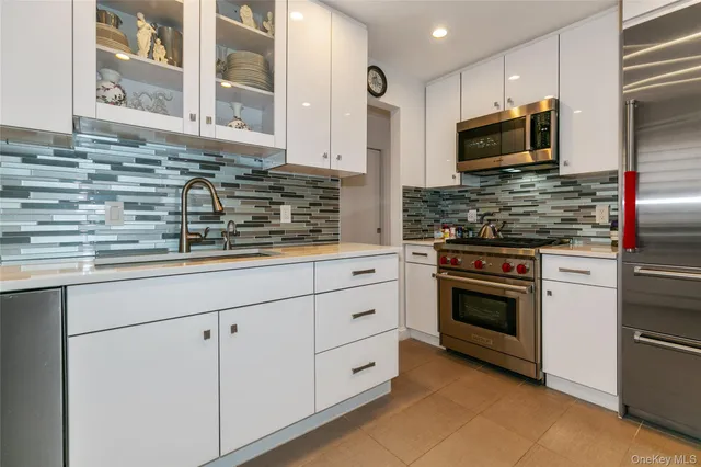 a kitchen with stainless steel appliances granite countertop a stove and a microwave