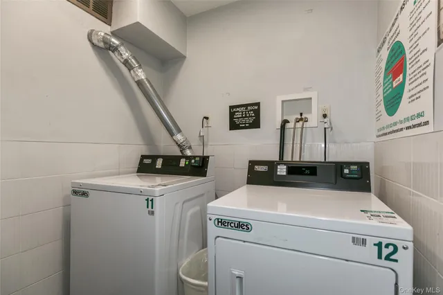 a view of washer and dryer with bathroom in the background