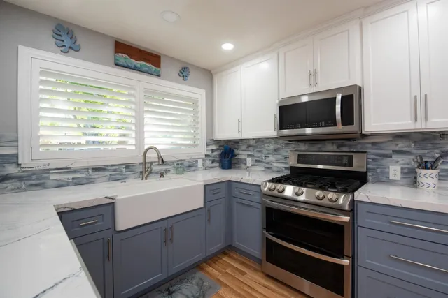 a kitchen with sink a microwave a stove and cabinets