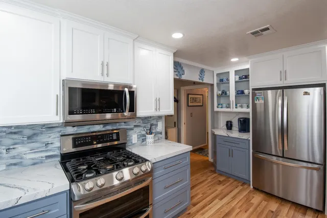 a kitchen with stainless steel appliances a refrigerator a stove and a microwave