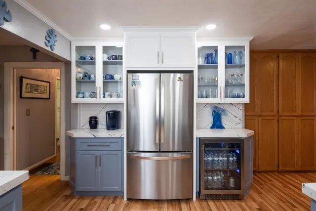 a kitchen with stainless steel appliances a refrigerator and a wooden floor