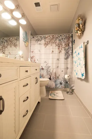 a bathroom with a sink a toilet and shower curtain