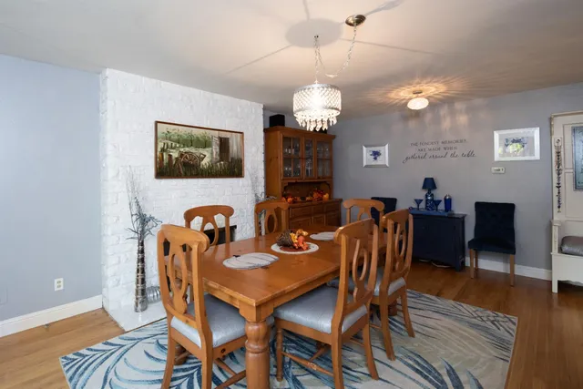 a view of a dining room with furniture wooden floor and chandelier