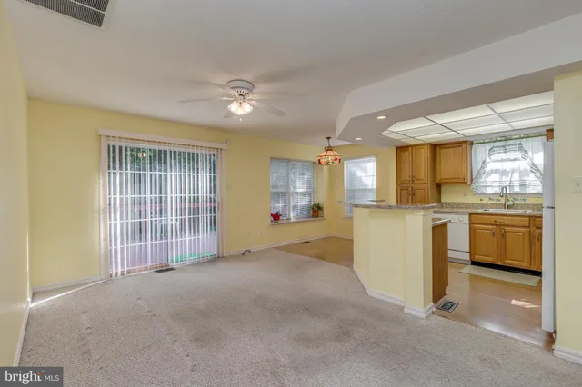 a view of a kitchen with refrigerator and white cabinets