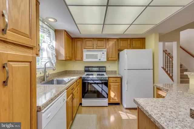 a kitchen with a sink a refrigerator and cabinets