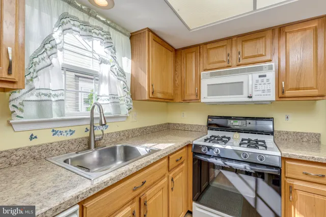 a kitchen with stainless steel appliances granite countertop a sink a stove and cabinets