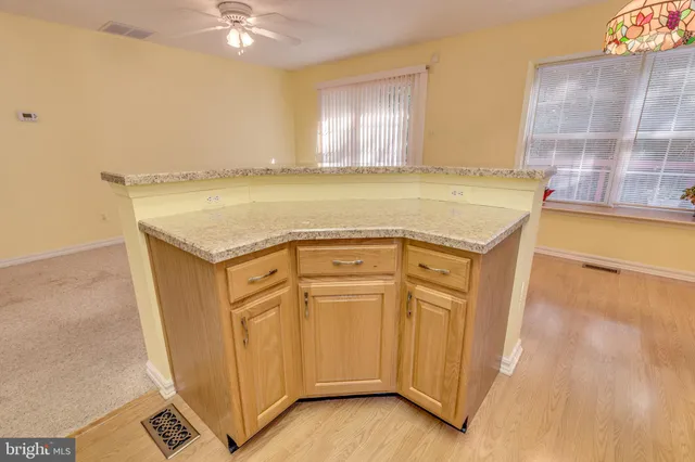 a view of a kitchen with stainless steel appliances wooden floor and cabinets