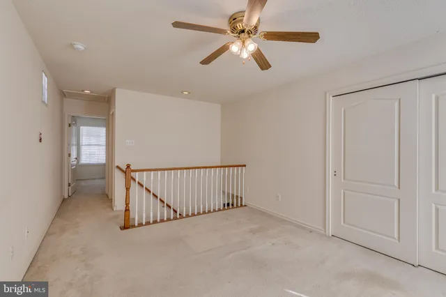 an empty room with fan and windows