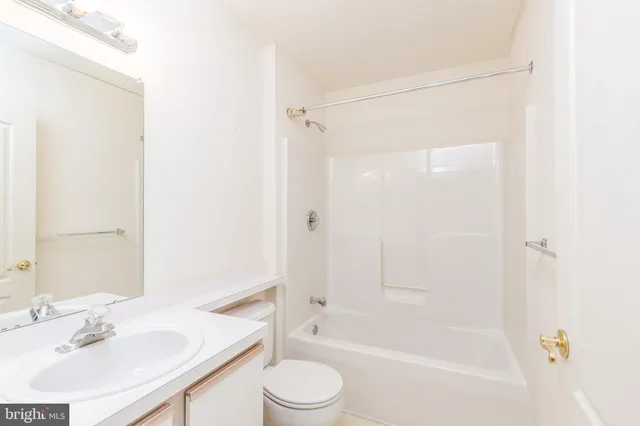 a bathroom with a bathtub shower sink vanity and toilet